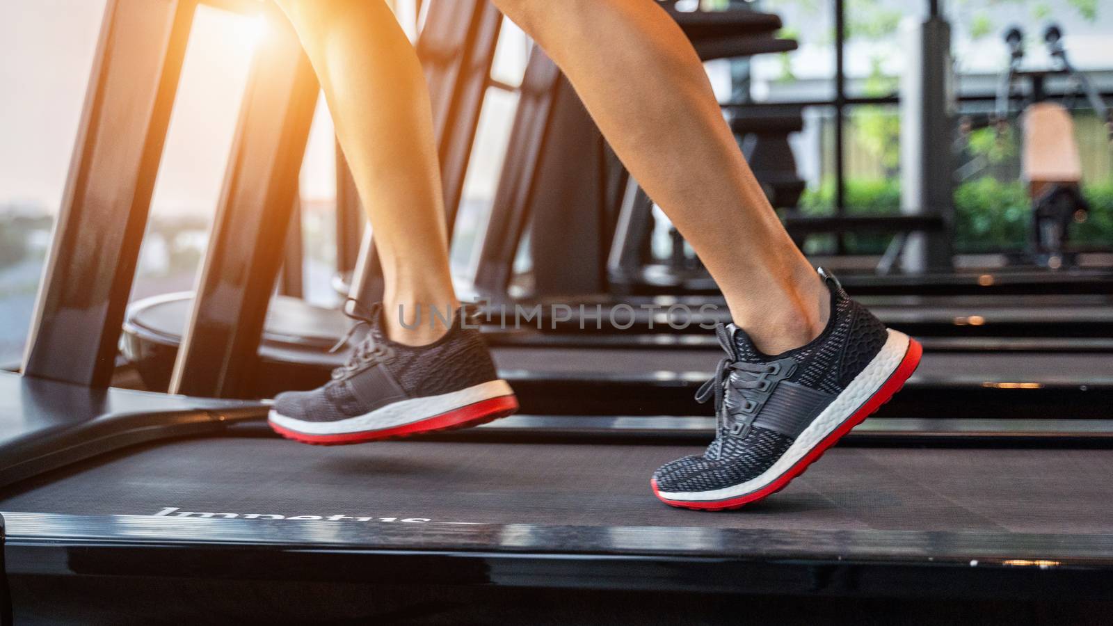 Male feet in sneakers running on the treadmill at the gym. Exercise concept. by gutarphotoghaphy