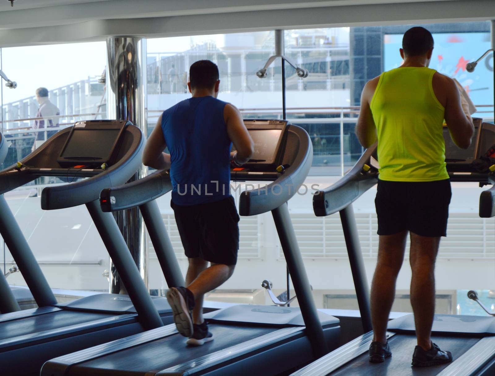 Modern gym with treadmills, people do sports on a cruise ship, the view from the back. MSC Meraviglia, 8 October 2018 by claire_lucia