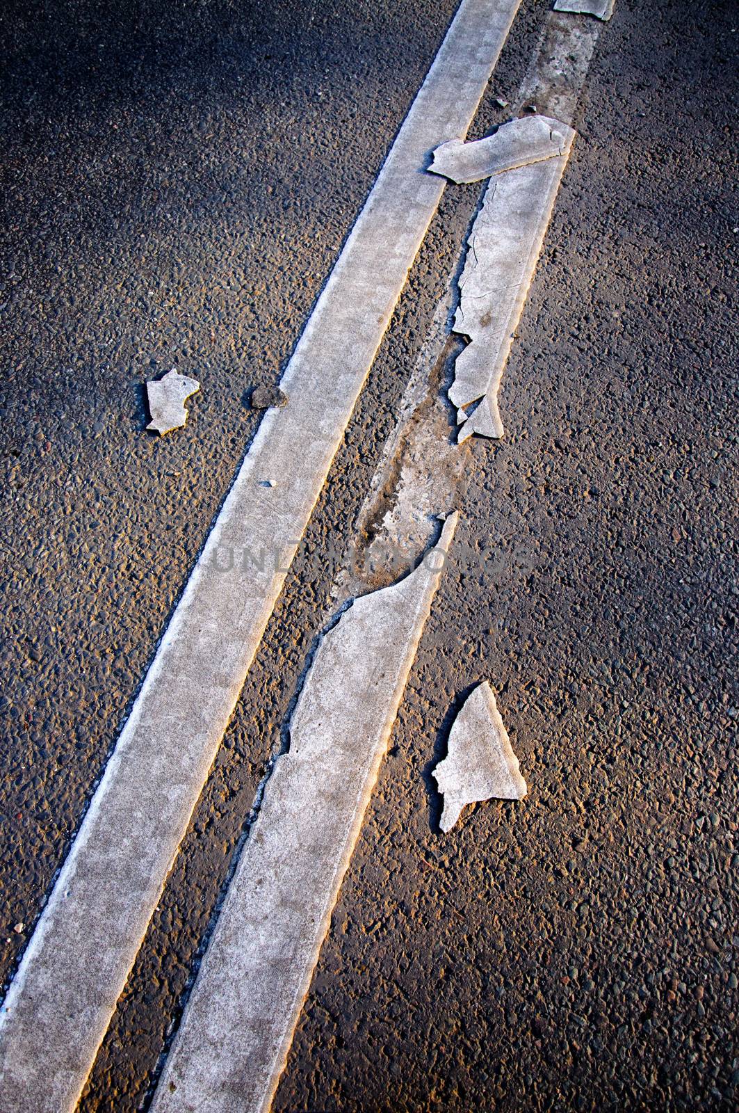 Brocken line of an asphalt road marking close-up.