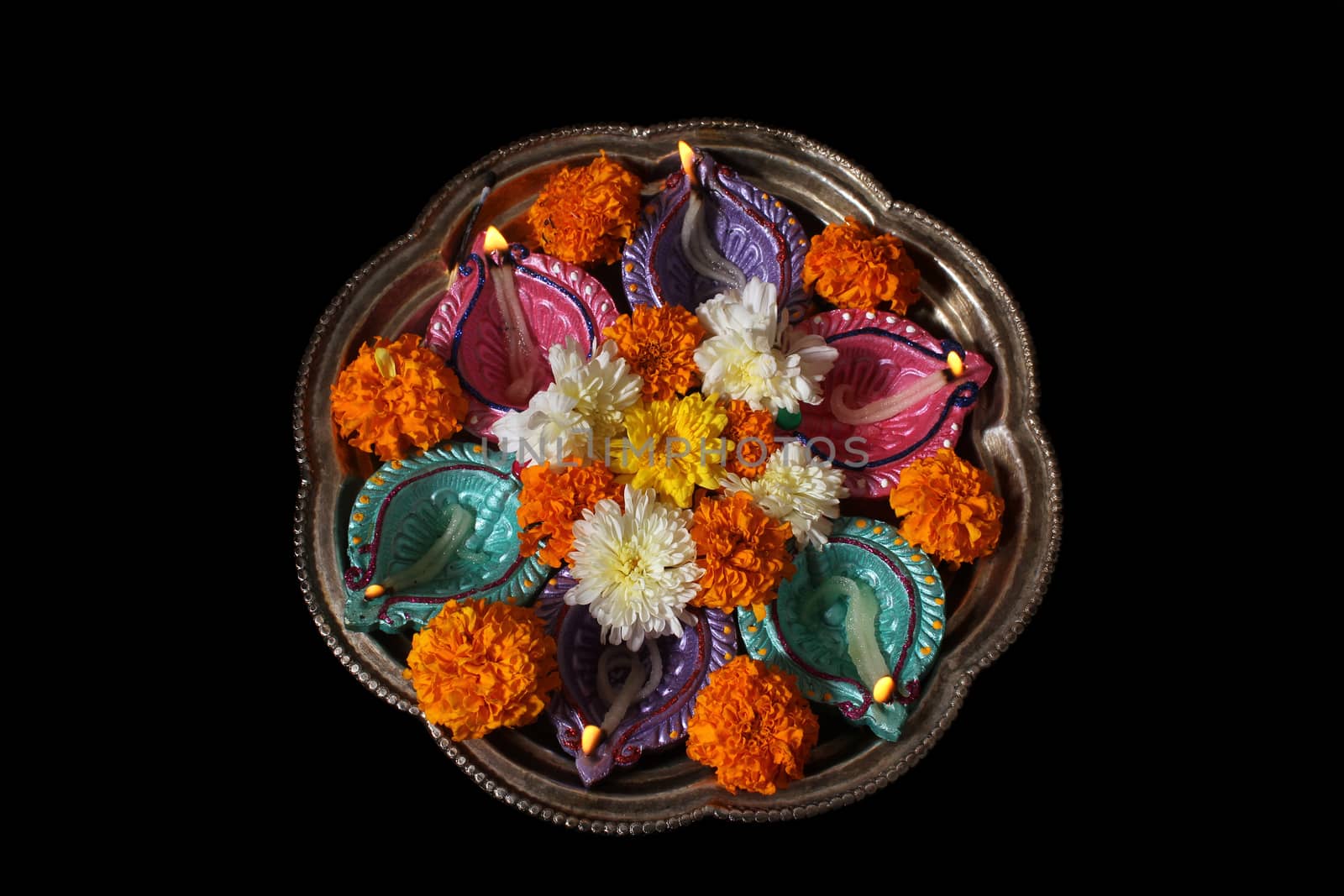 A plate used for traditional hindu rituals with lamps and flowers during Diwali festival in India.