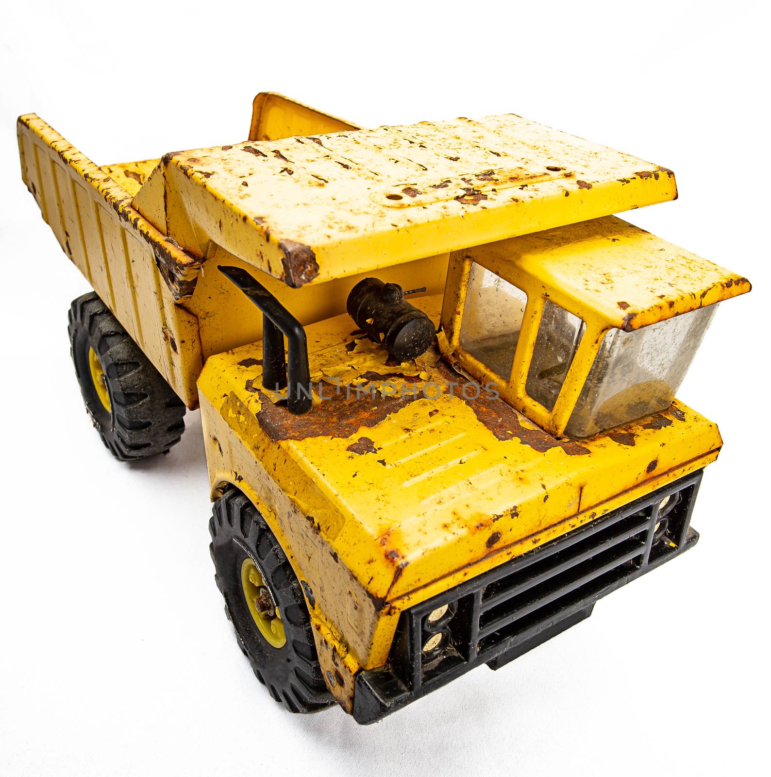 Rusted yellow toy truck isolated against white background