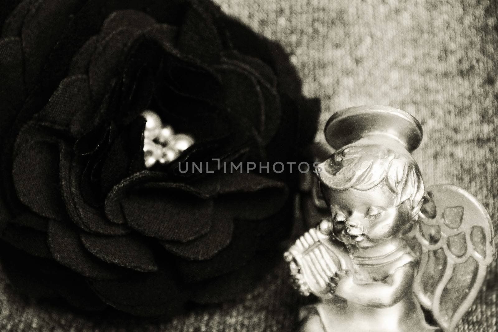 An artificial rose made of cloth and an angel playing on a lyre. a photo. vintage