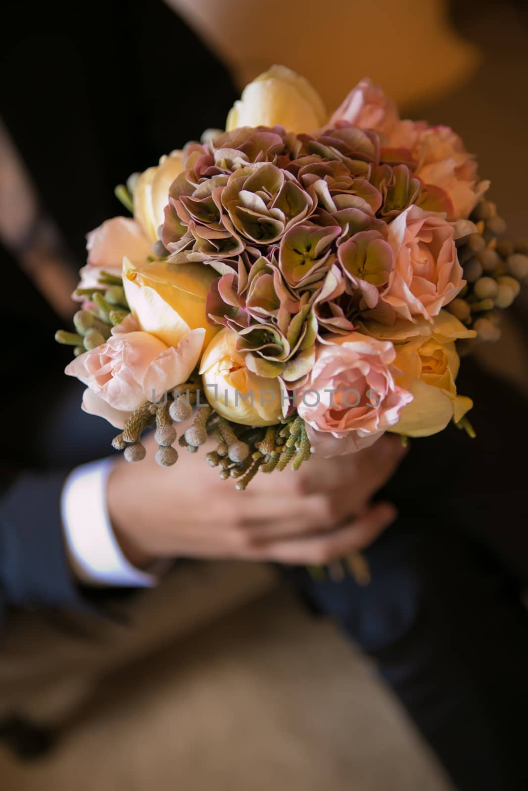 Groom holding in hands delicate, expensive, trendy bridal wedding bouquet of flowers by sarymsakov