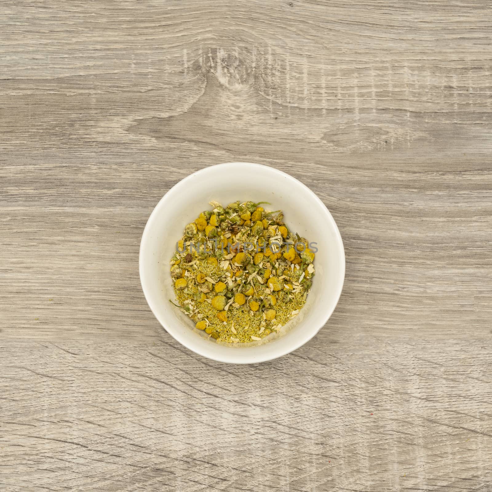 dried chamomile flowers in a white bowl