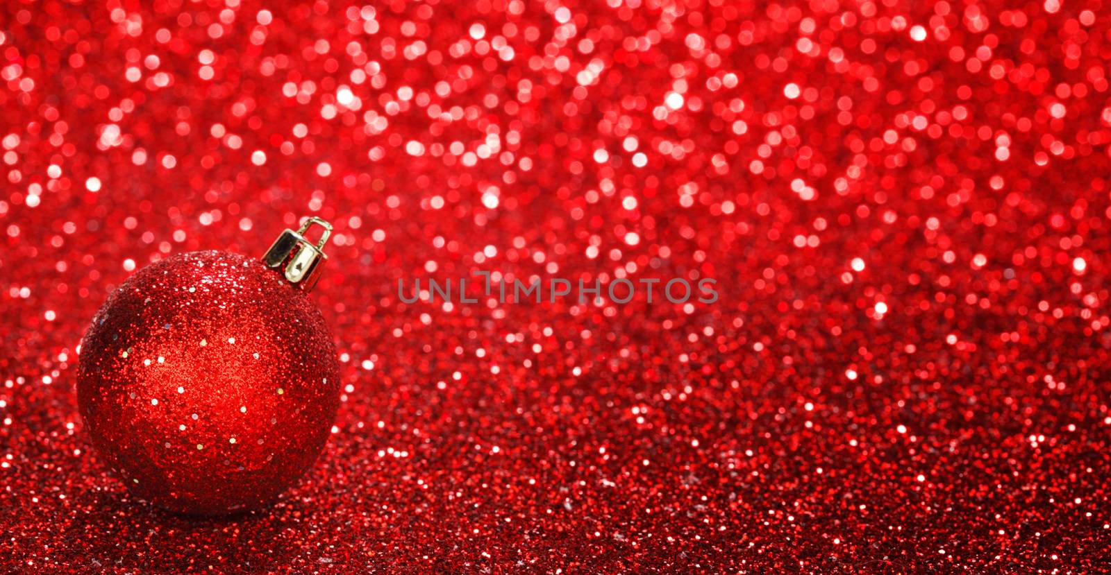 Red christmas ball over shiny glitter background