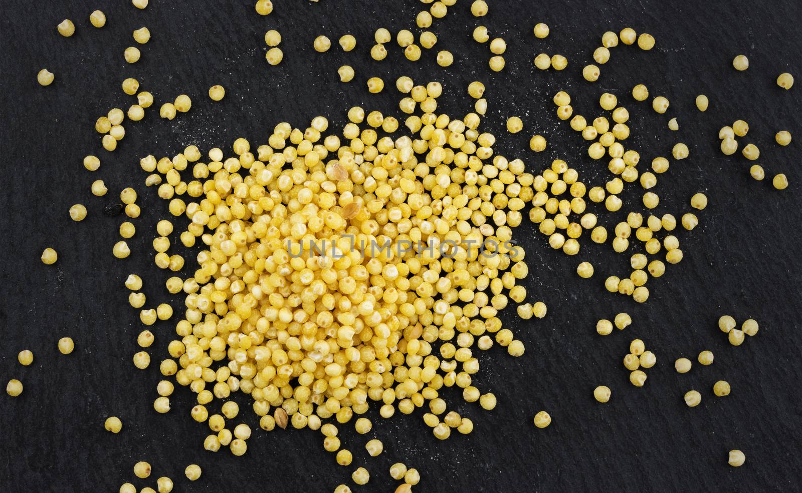 Heap of millet grains on black background. Top view by xamtiw