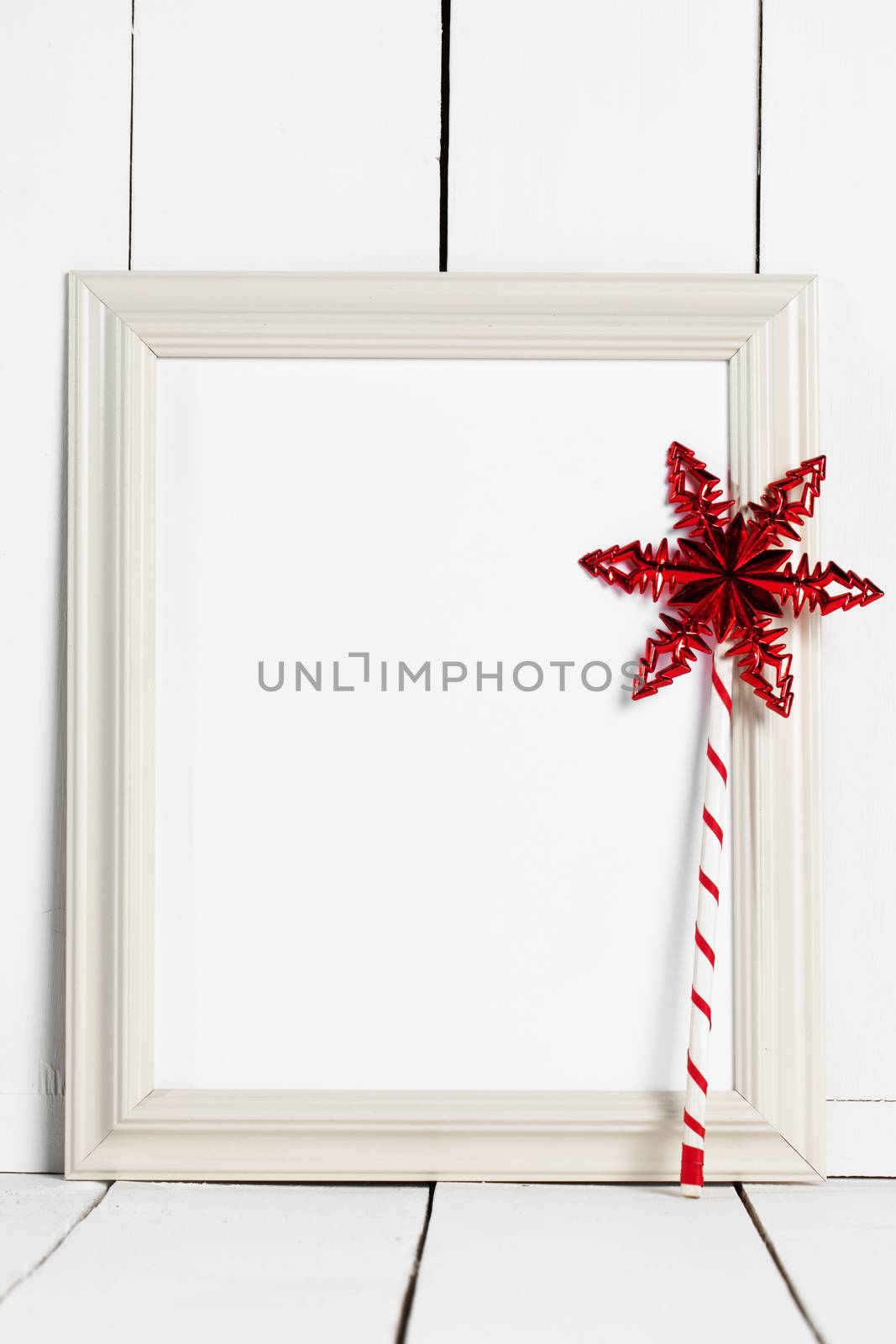 Vintage white wooden picture frame with blank white copy space and red star magic wand