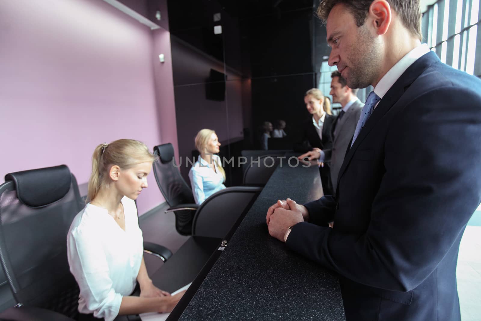 Business people at front desk by ALotOfPeople