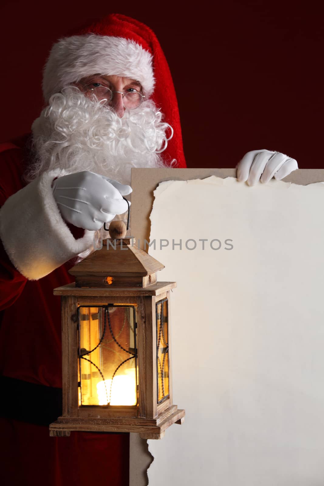 Santa Claus with lantern holding vintage paper billboard with copy space for text