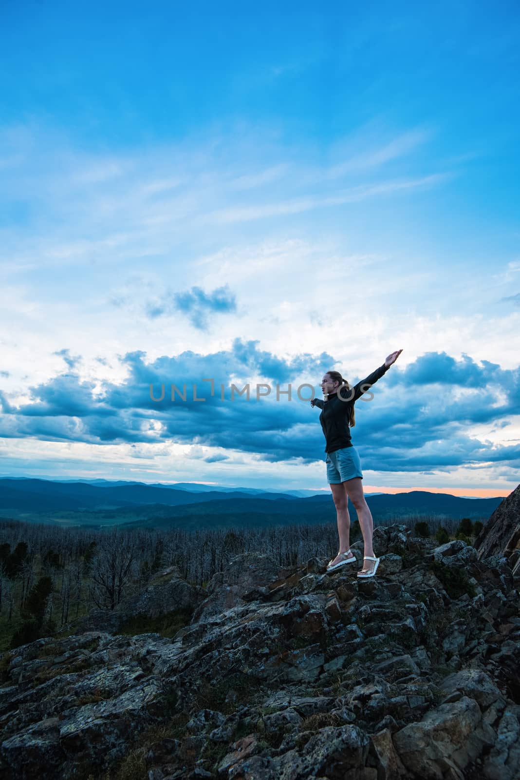 Travel, lesure and freedom concept - woman on the top of Altai mountain, beauty summer evening landcape