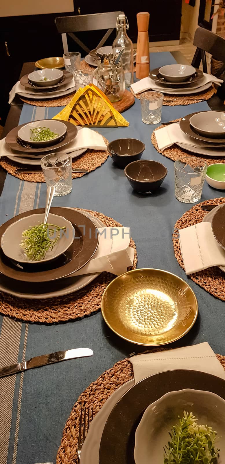 On the festive table in the wedding banquet area there are plates, glasses, candles, cutlery, the table is decorated with compositions in brown