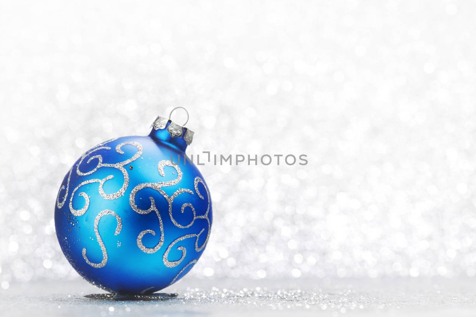 Christmas decorative ball on light silver bokeh background