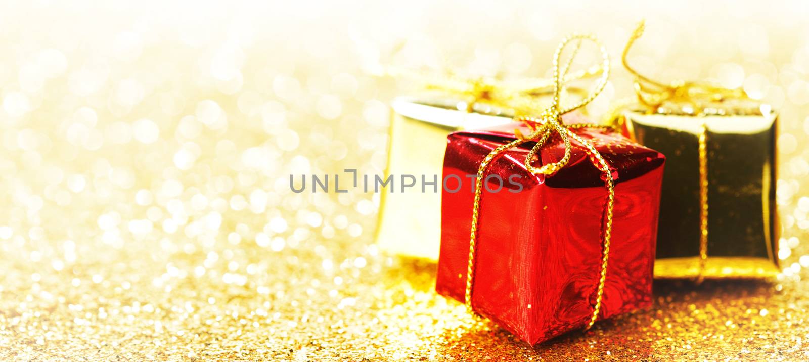 Decorative boxes with holiday gifts on abstract gold background