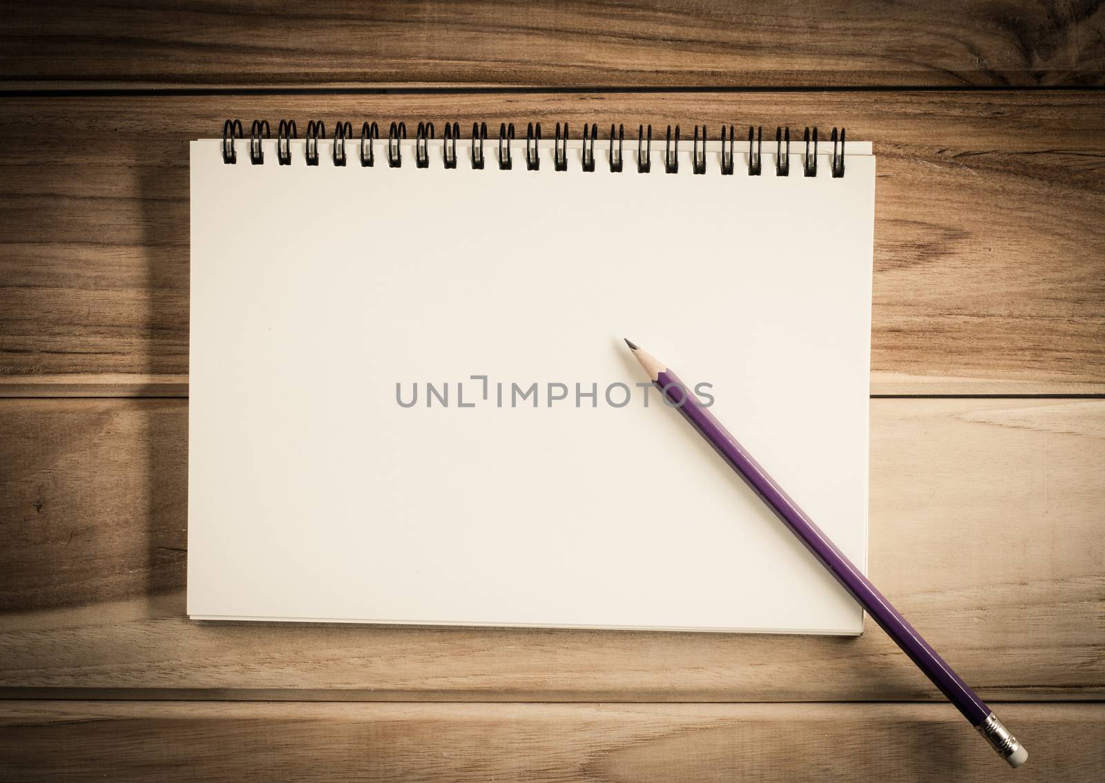 blank notebook with pencil on wooden table - still life