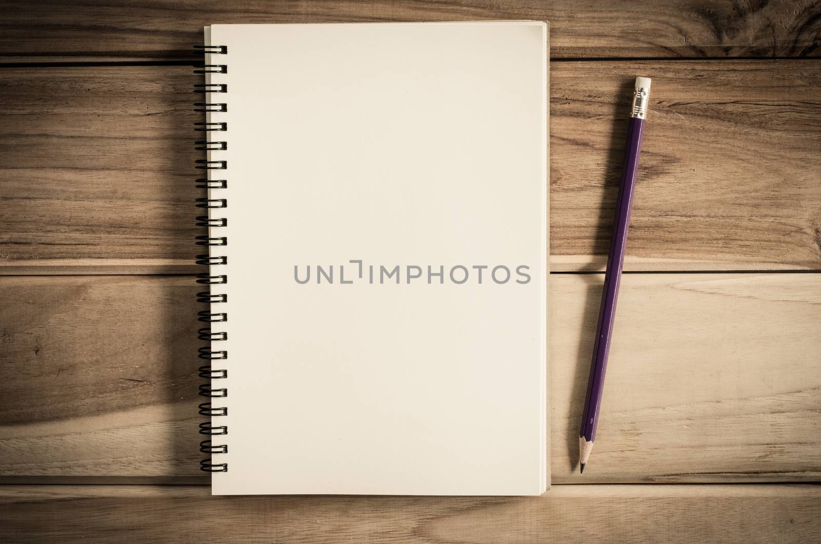 blank notebook with pencil on wooden table - still life by photobyphotoboy