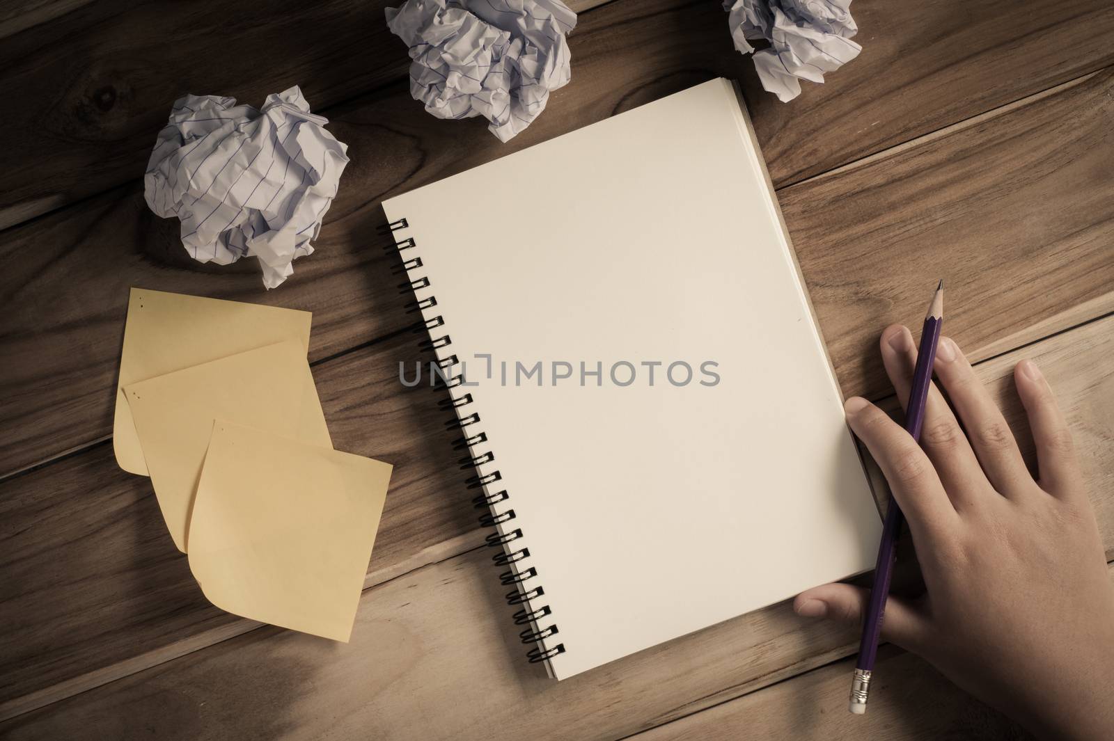 Hand-written note in pencil on a wooden table - hand focus