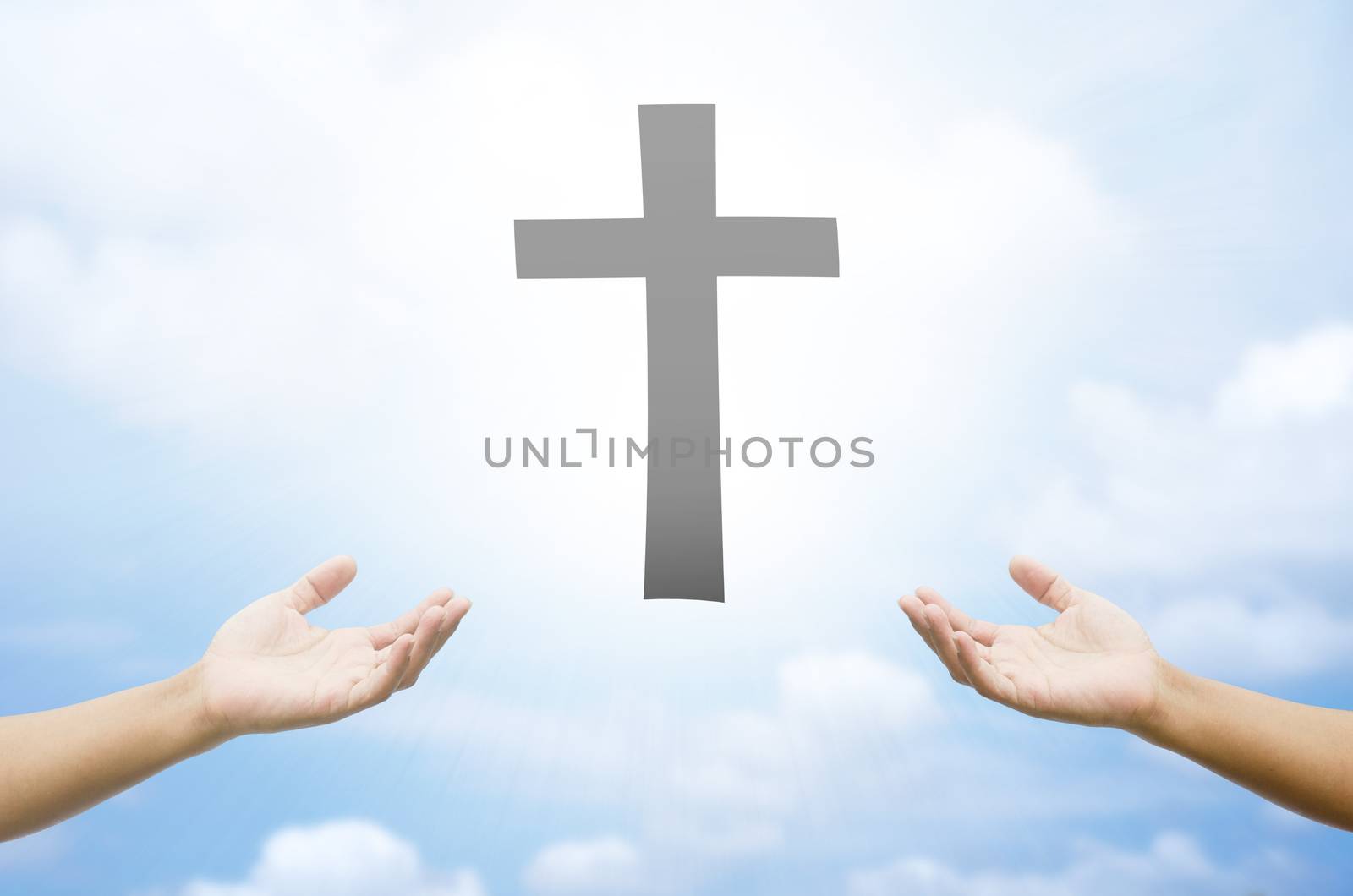 open hands praying the cross on blur sky background.