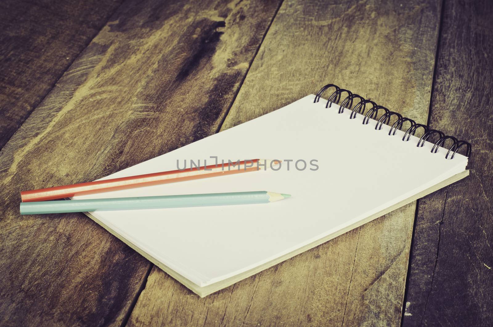 Color pencil and sketchbook on wooden background by photobyphotoboy