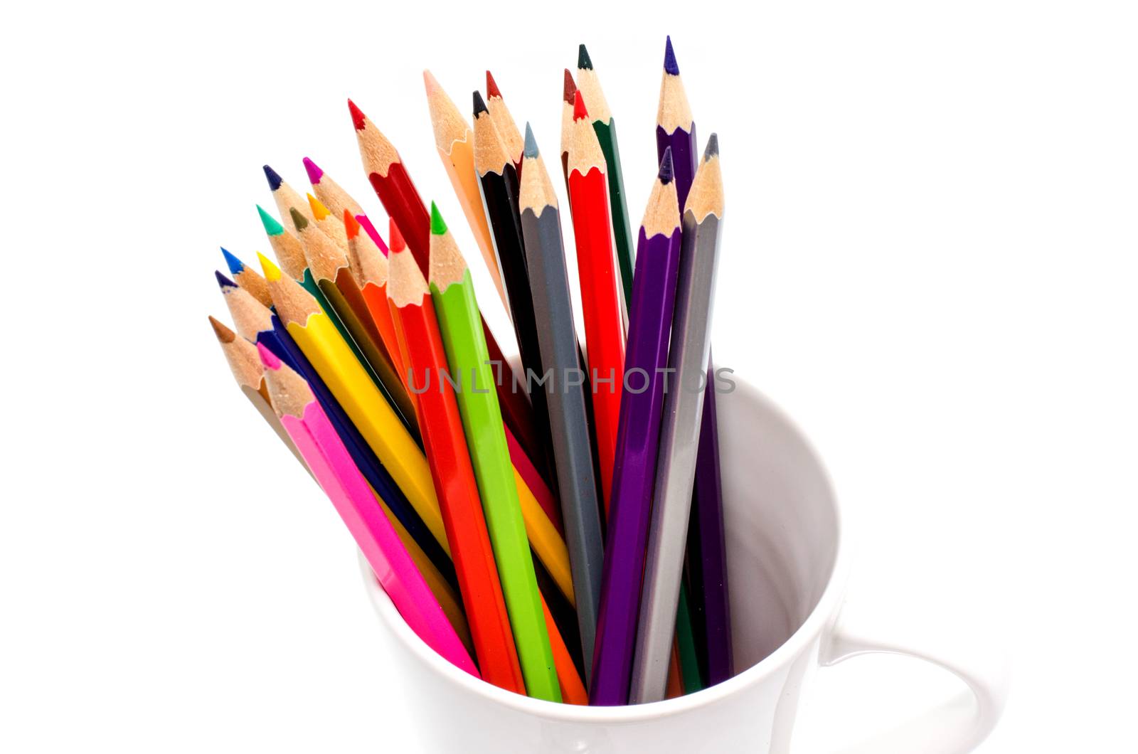 Stack of colored pencils in a glass on white background by photobyphotoboy