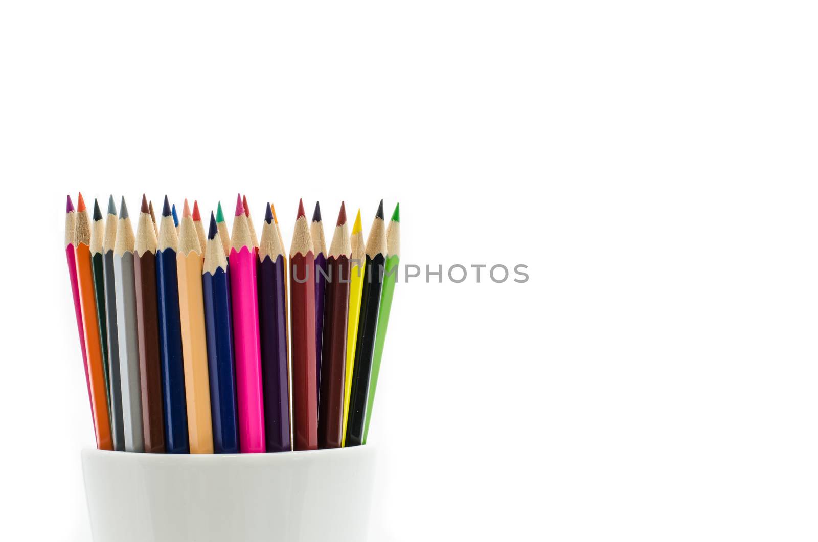 Stack of colored pencils in a glass on white background by photobyphotoboy