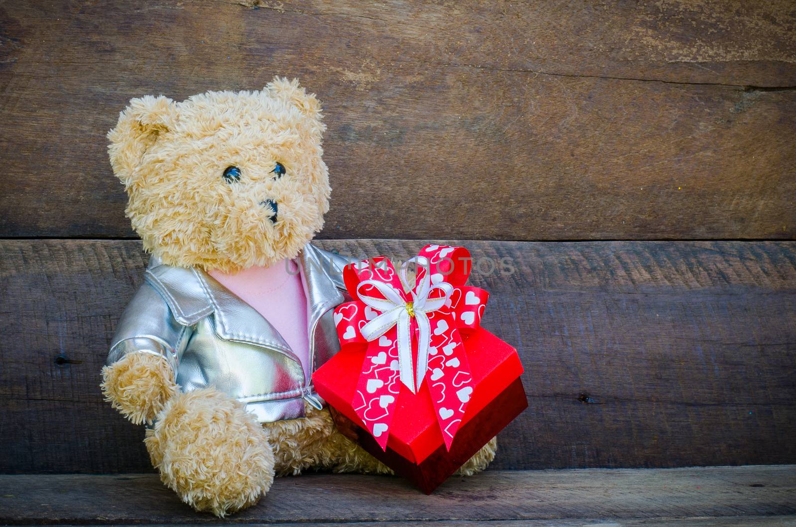 teddy bear and gift on wooden background by photobyphotoboy