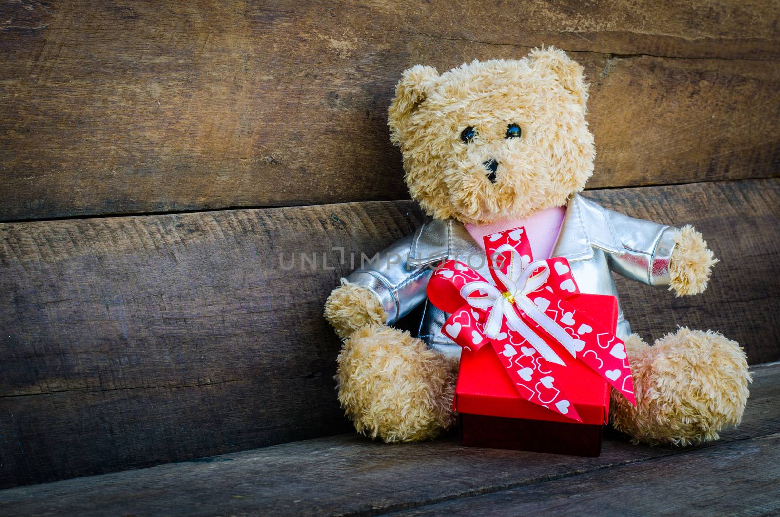 teddy bear and gift on wooden background