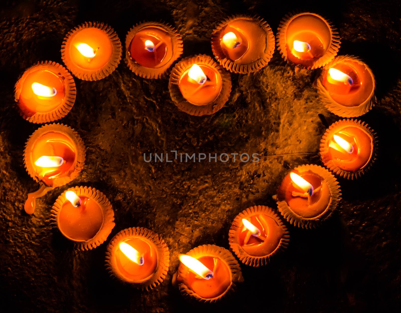 light a candle with heart shaped with floor background