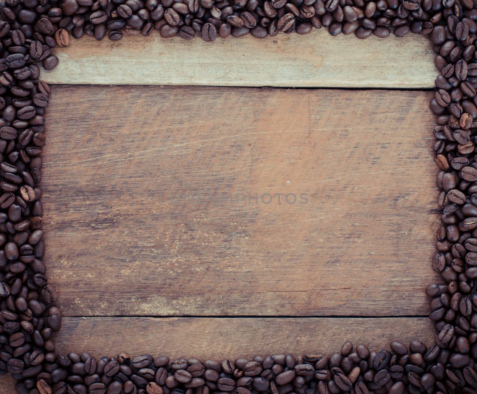Rectangle frame made of coffee beans on the wooden background by photobyphotoboy