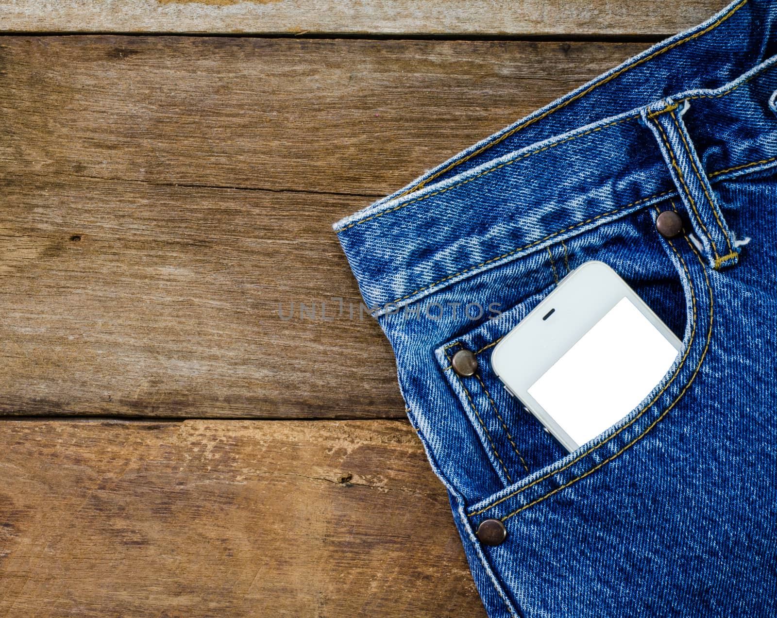 smart phone in pocket jeans on wooden background
