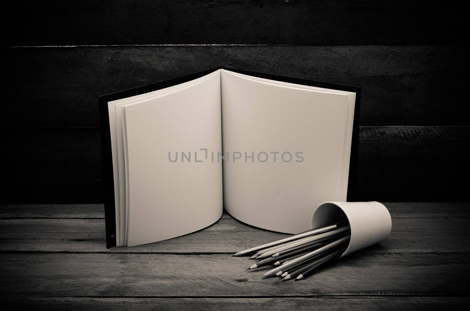 Color pencil and sketchbook on wooden background by photobyphotoboy