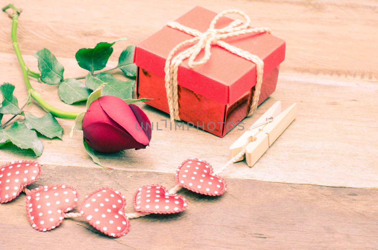 roses and gift box on wooden background by photobyphotoboy