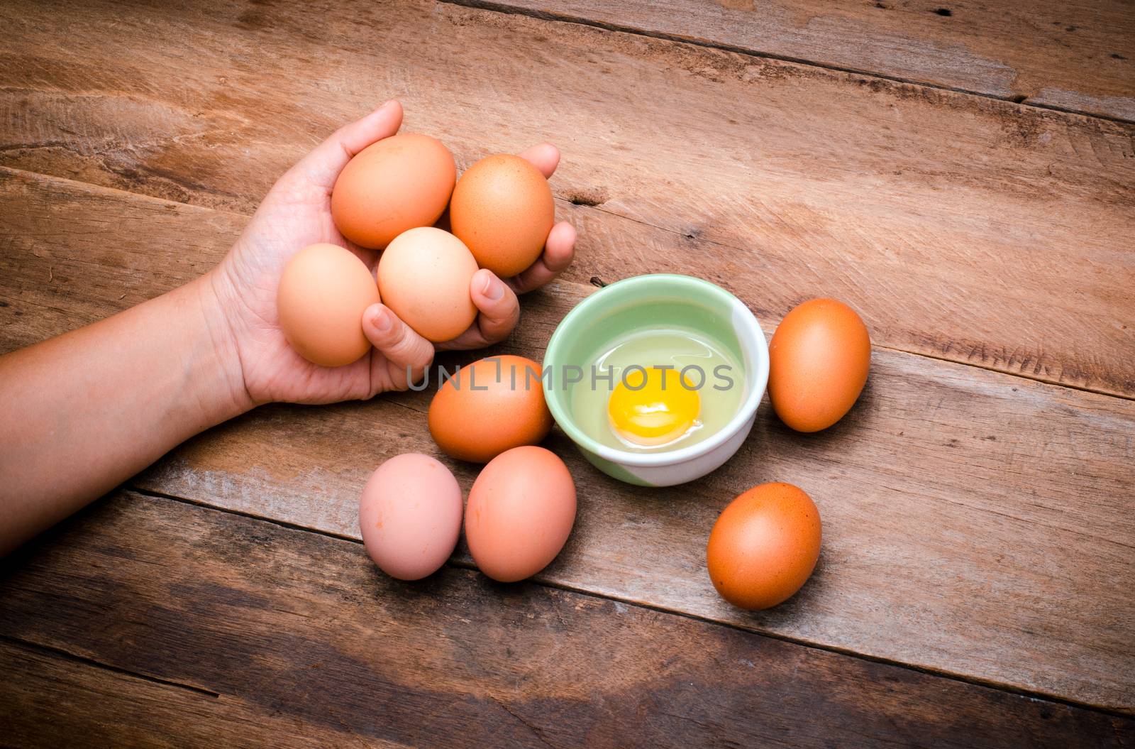 woman holding egg with her hand on wooden by photobyphotoboy