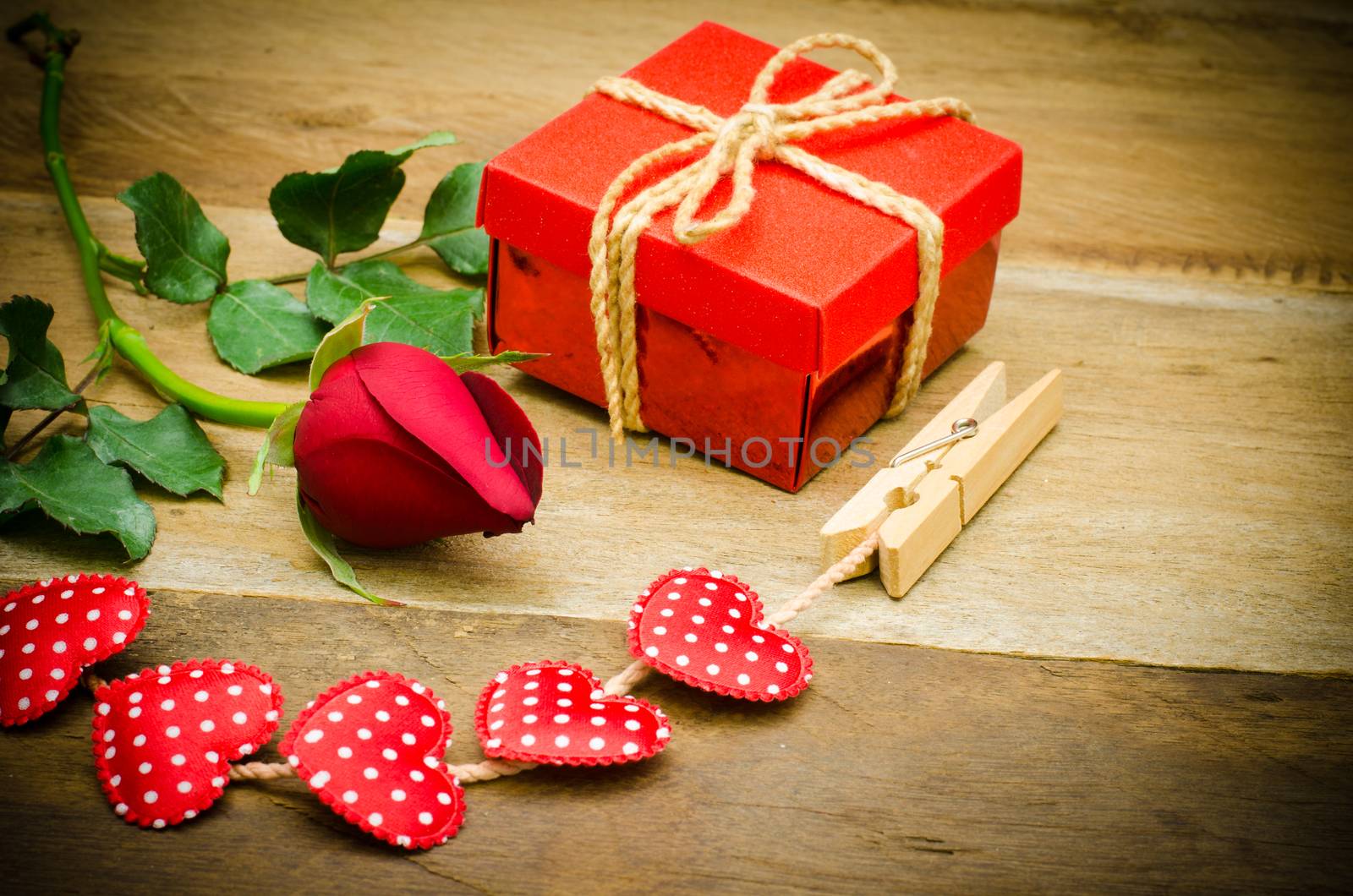 roses and gift box on wooden background