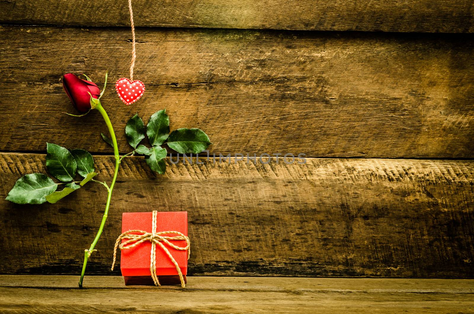 roses and gift box on wooden background