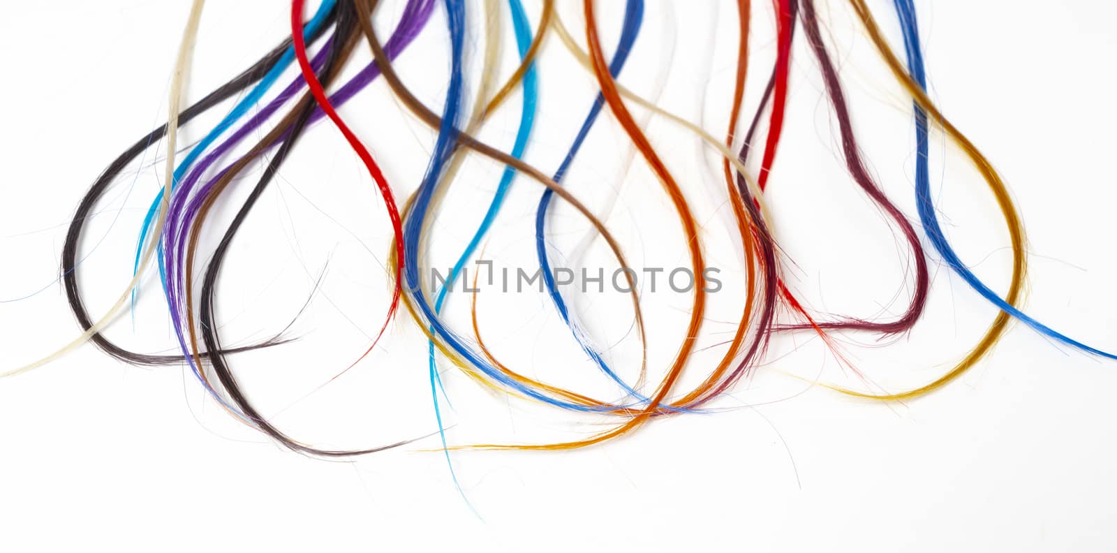 long strands of colored hair on a white surface