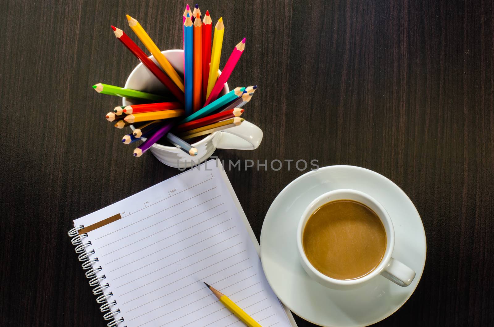 notebook pencill and cup of coffee in wood table
