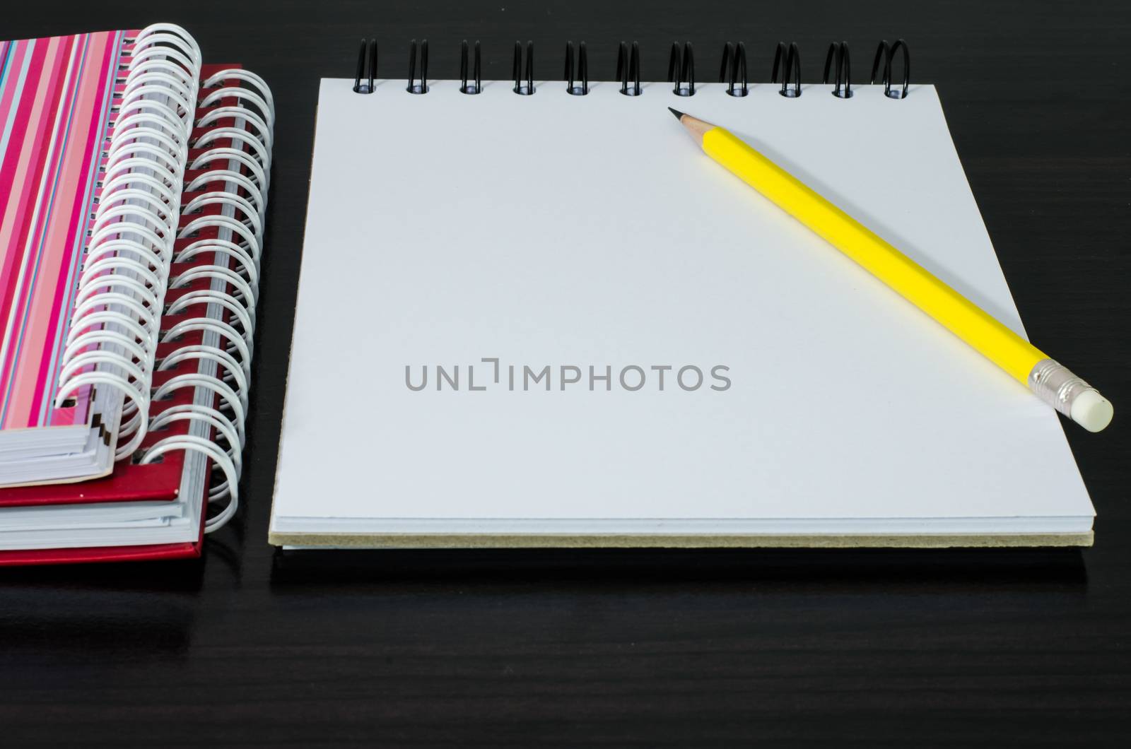 blank notebook with pencil on wooden table by photobyphotoboy