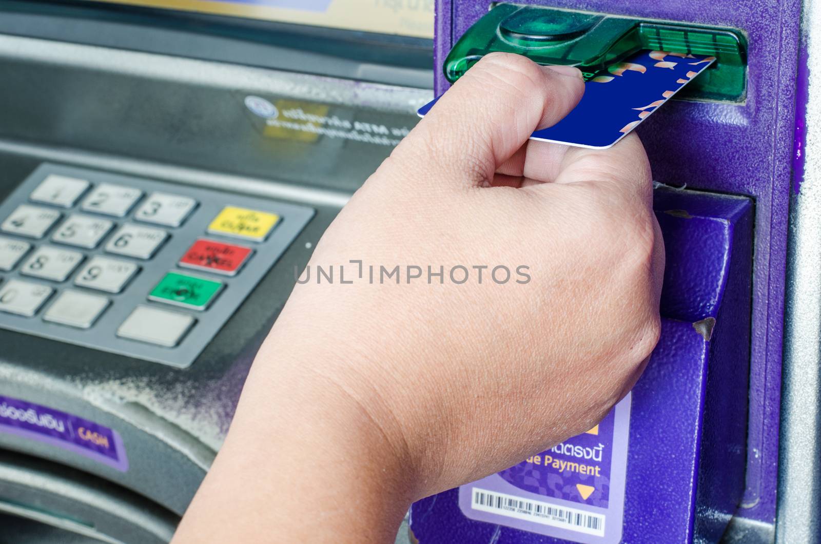 Hand inserting ATM credit card into bank machine