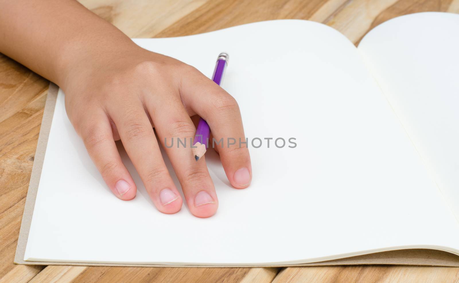Hand writing in open notebook on table