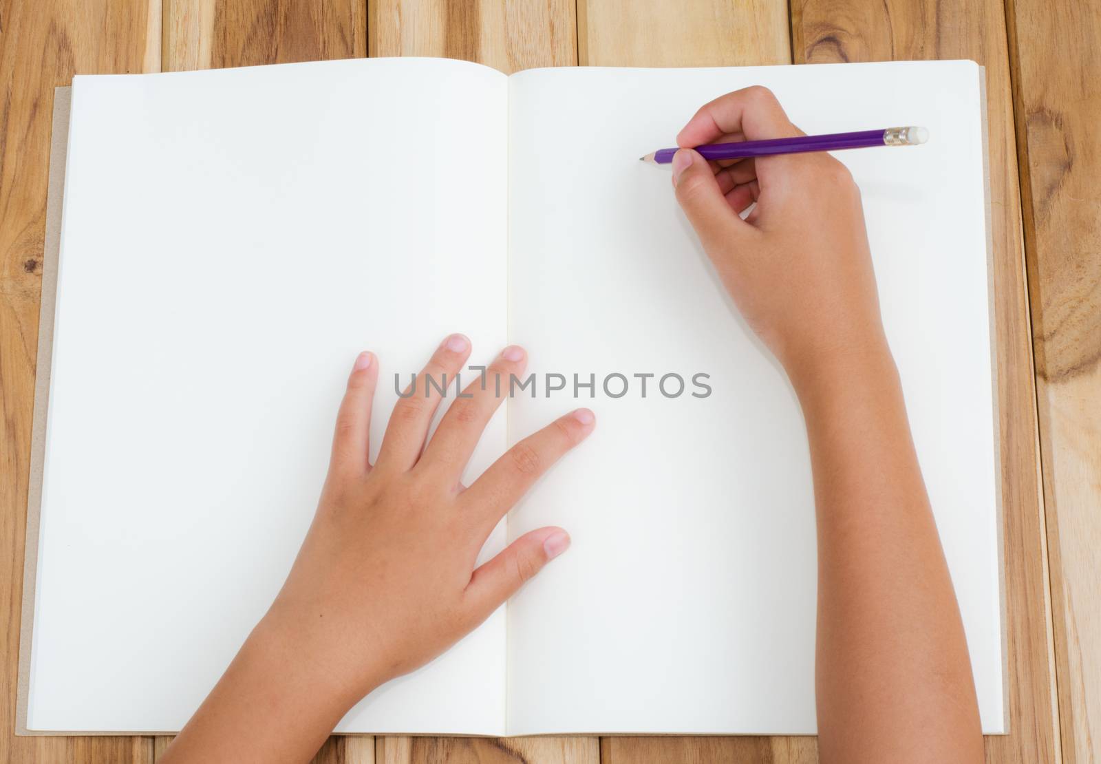 Hand writing in open notebook on table