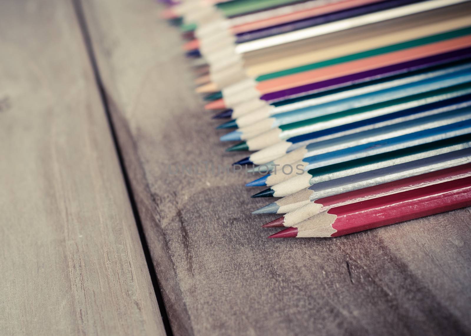 Pastel colors are arranged on a wooden table.