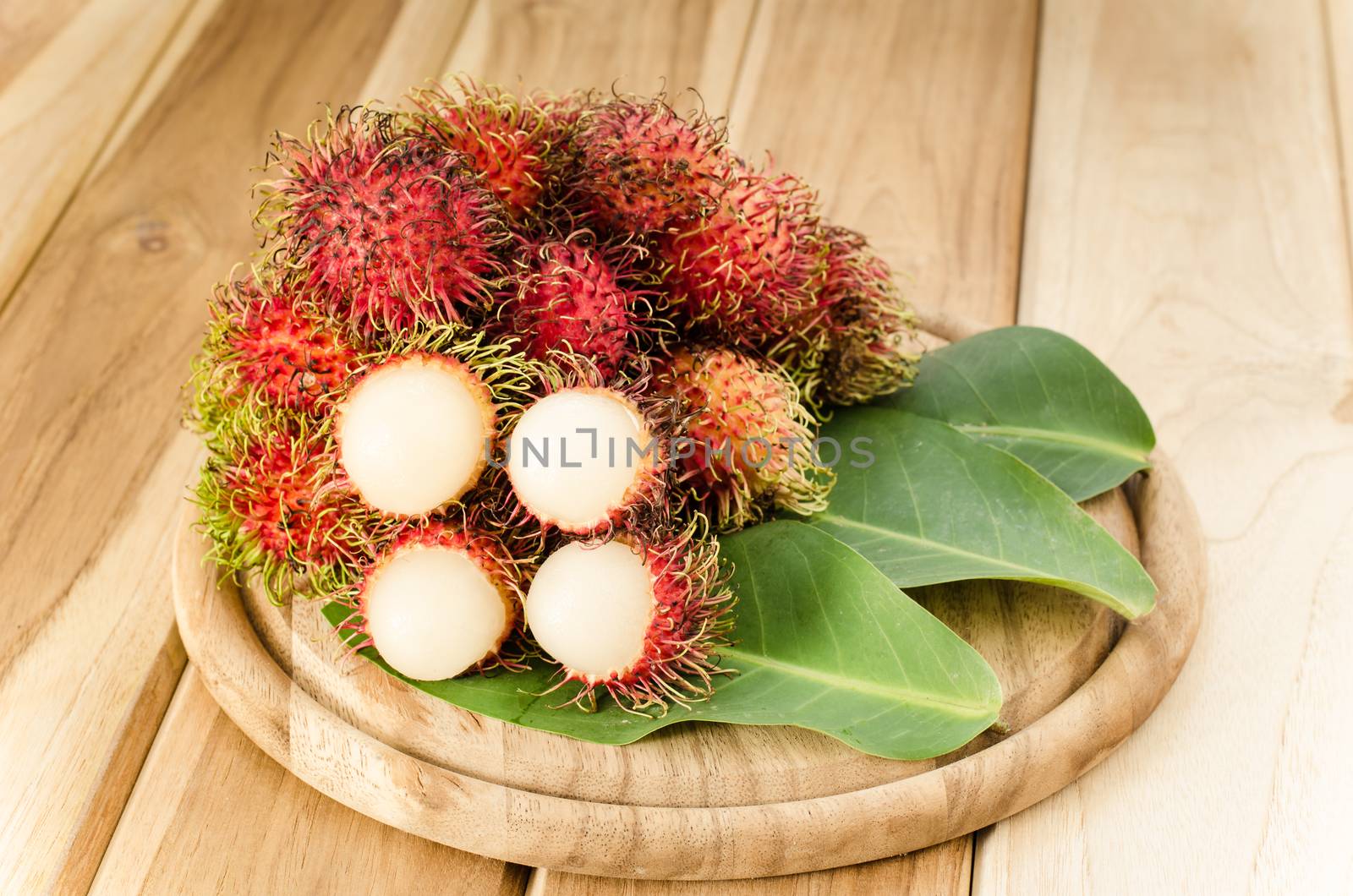 Red rambutan on wooden background.