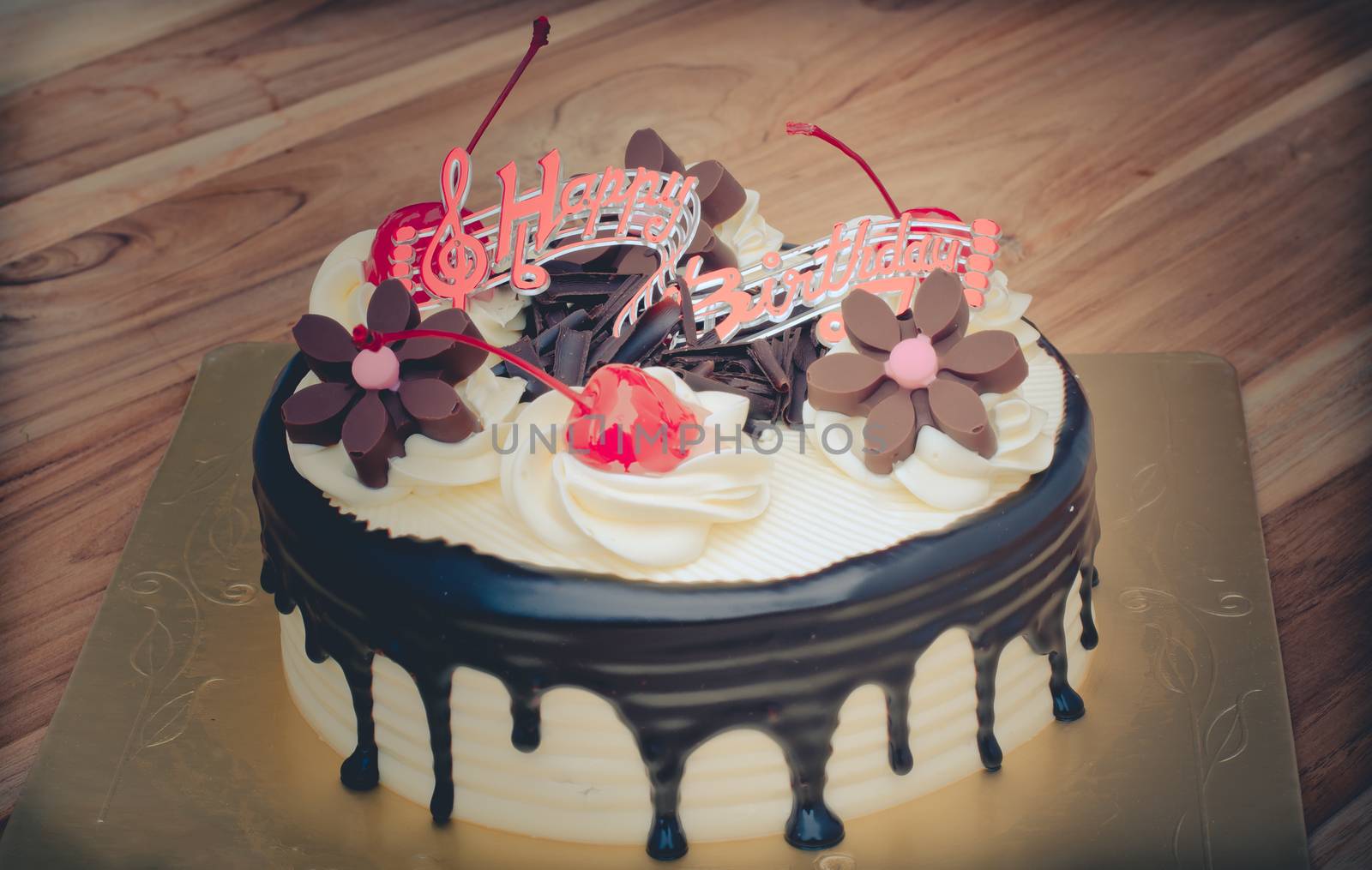 Birthday cake, vanilla Chocolate Cherry was divided pieces on a wooden table.