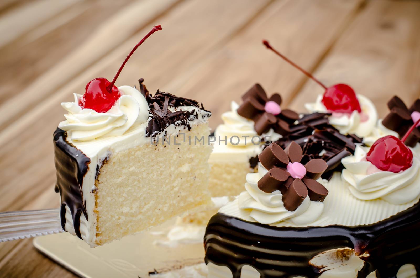 Birthday cake, vanilla Chocolate Cherry was divided pieces on a wooden table.