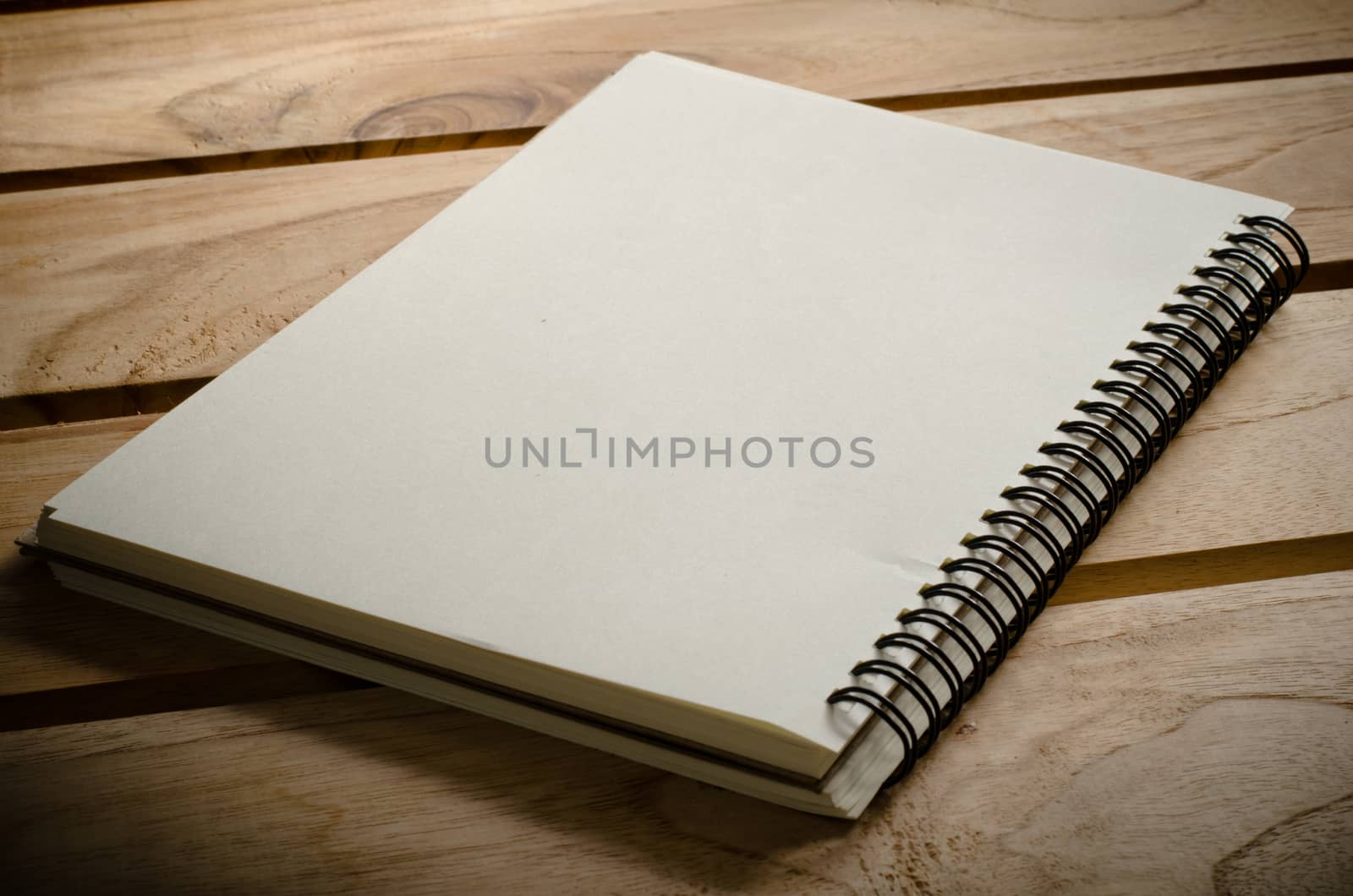 White notebooks laying on a wooden table