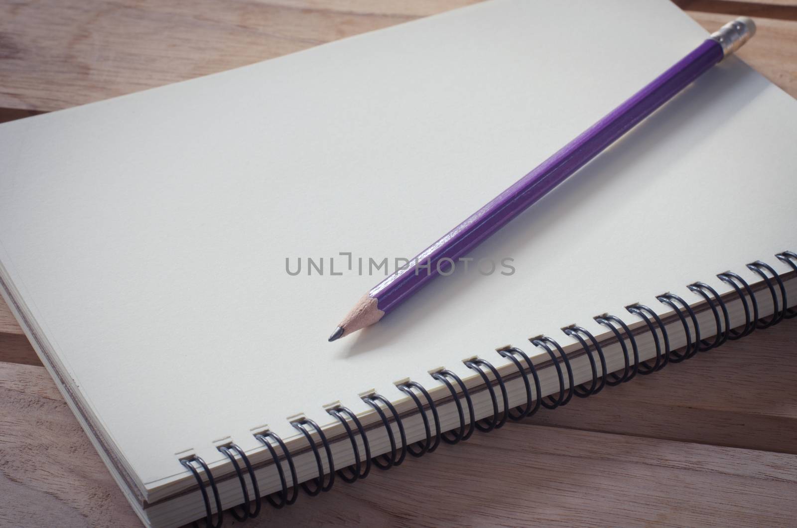 blank notebook with pencil on wooden table - still life