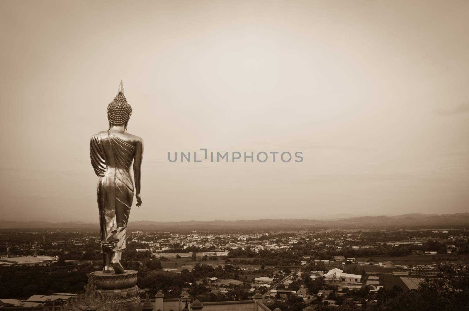 Golden Buddha standing on a mountain Wat Khao Noi, Nan, Thailand, surrounded by natural beauty.