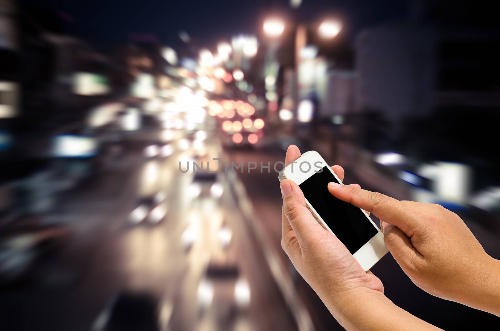Mobile smart phone behind a blur of traffic.