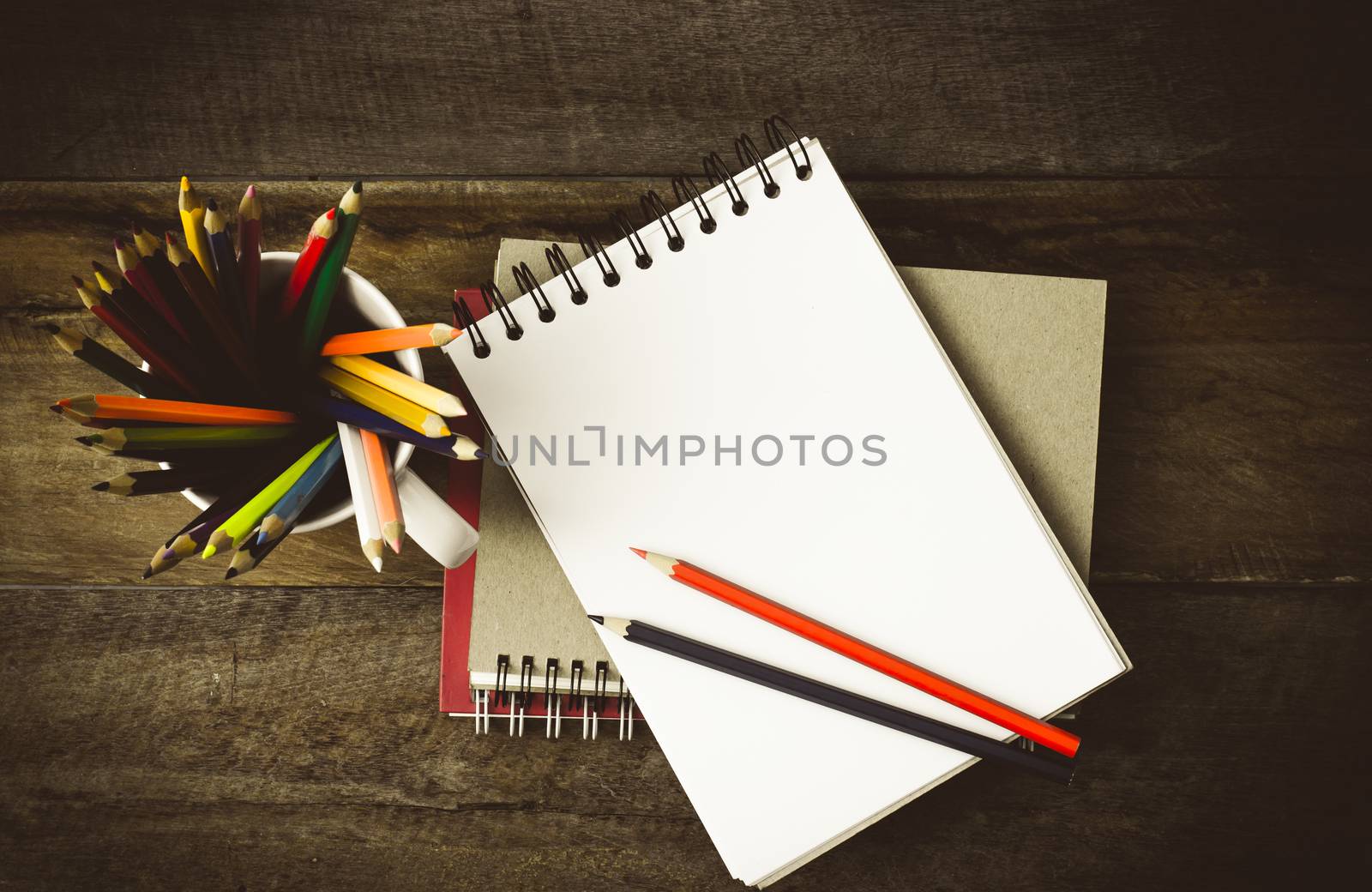 Color pencil and sketchbook on wood table