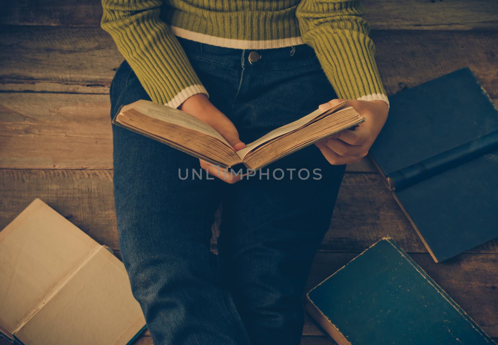 reading book on wooden floor with book - tone vintage